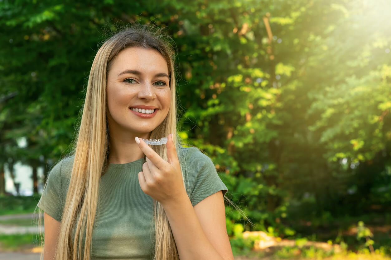 woman holding invisible aligner orthodontic