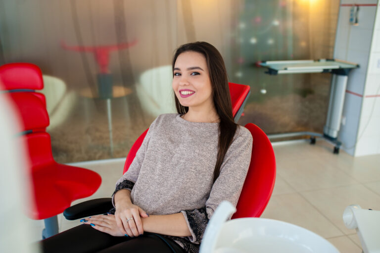 Smiling patient sitting comfortably in a dental chair.