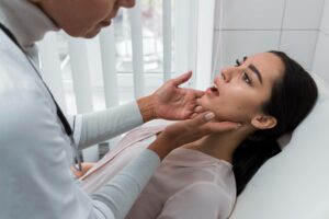 Dentist examining a patient’s jaw during a cosmetic dental consultation.