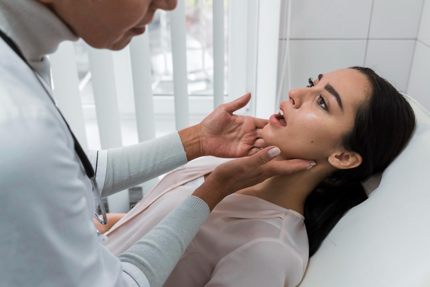 Dentist examining a patient’s jaw during a cosmetic dental consultation.
