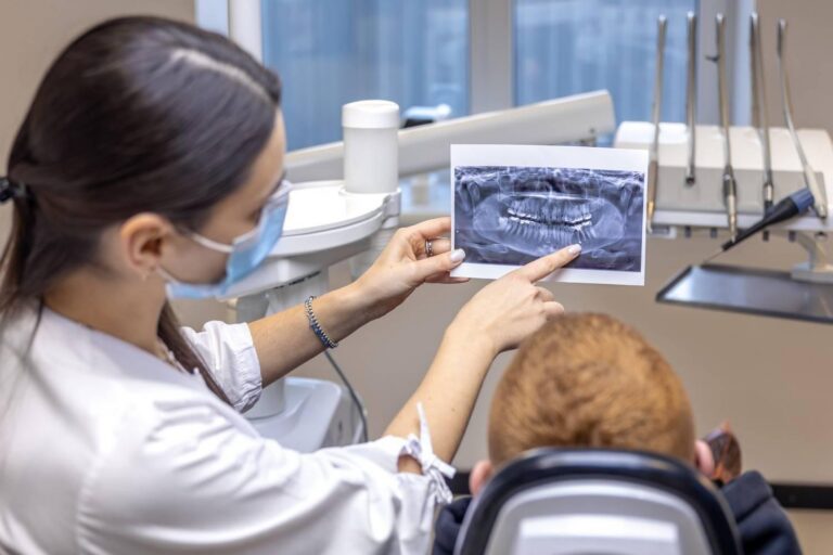 Dentist explaining a dental X-ray to a patient during a consultation.
