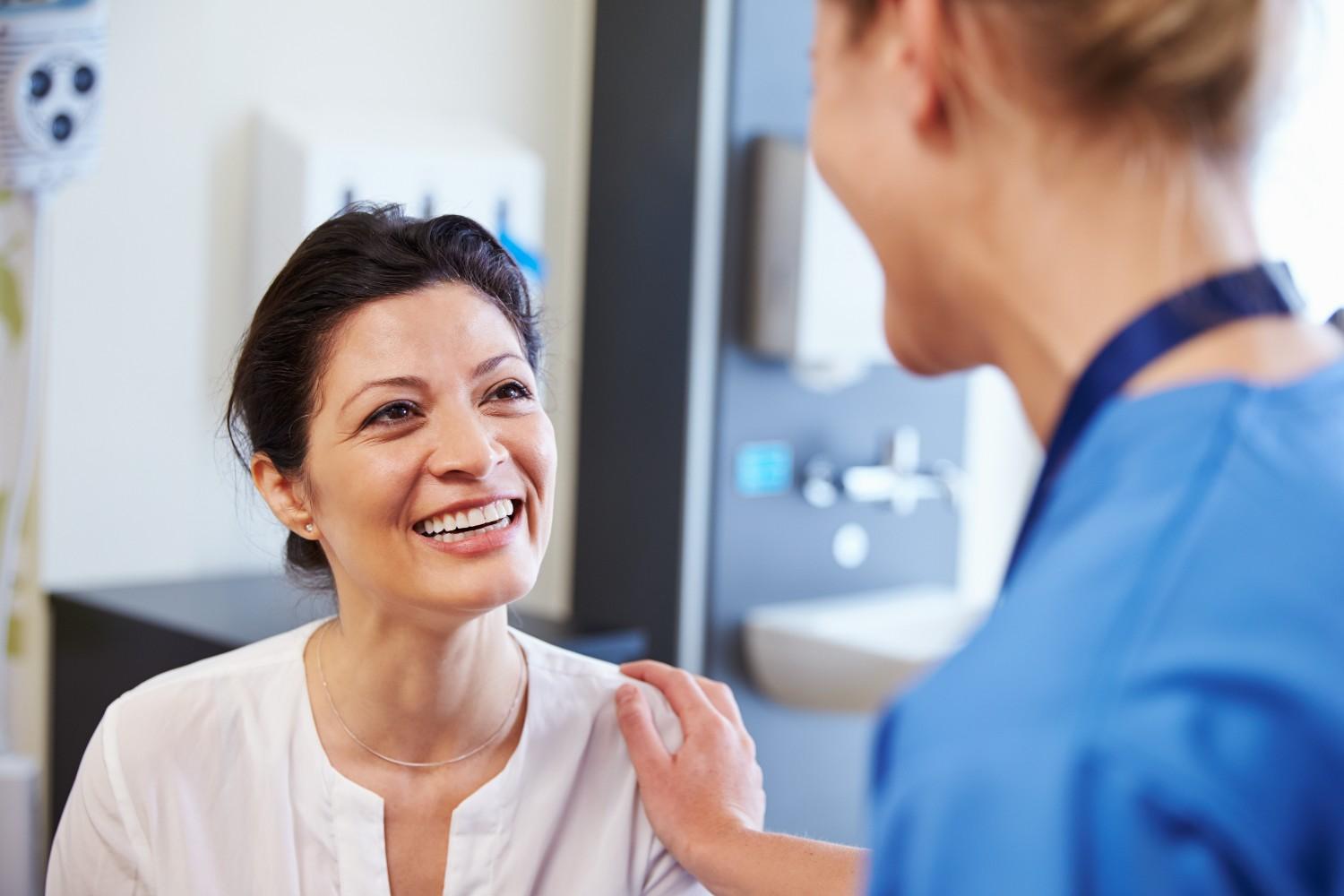 Smiling dental patient talking with dentist