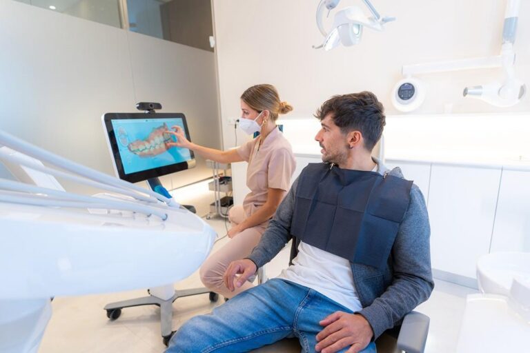 Dentist showing a patient a digital dental scan in a modern exam room.