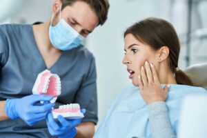 Patient reacting while a dentist explains a dental model.