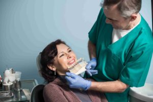 Dentist matching tooth shade with patient