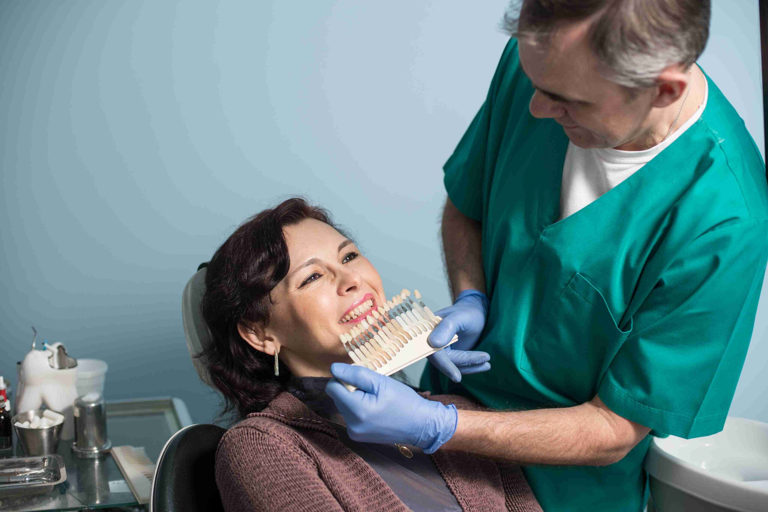 Dentist matching tooth shade with patient
