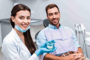 Dentist showing a dental model to a patient.