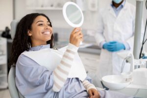 Patient admiring her smile in a mirror.