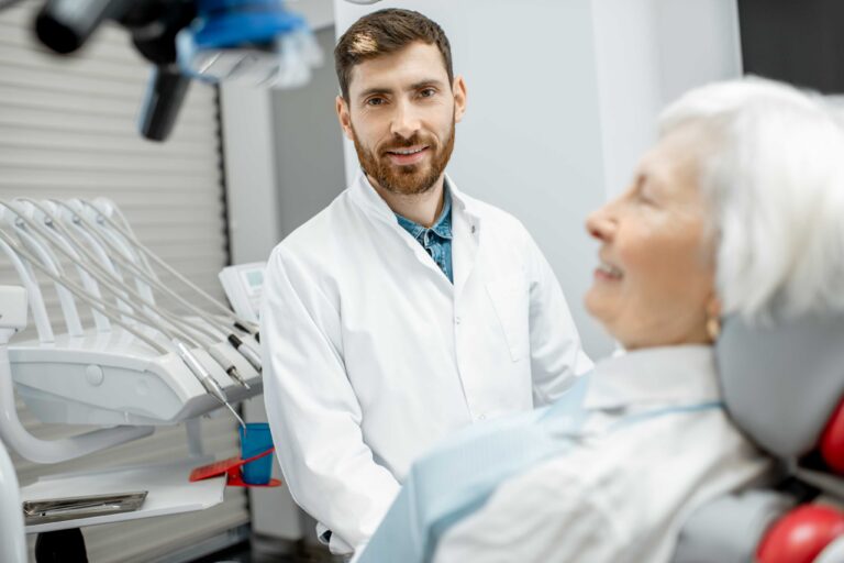Dentist speaking with an older patient.