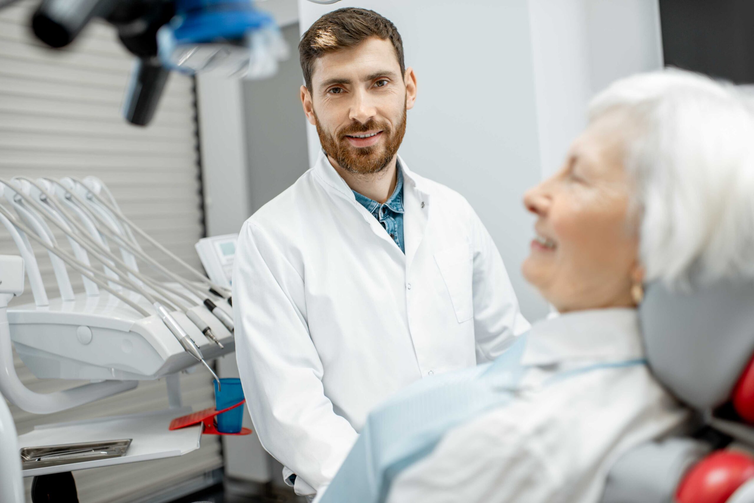 Dentist speaking with an older patient.